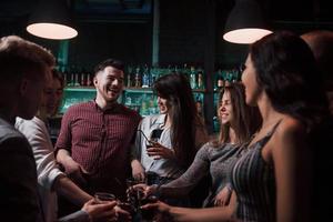 nya bekantskaper. vackra ungdomar har fest tillsammans med alkohol på nattklubben foto