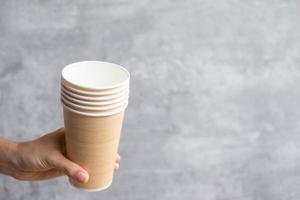 miljövänlig matförpackning eller takeaway kaffekopp. hand som håller naturlig behållare för att gå. noll avfall, föroreningar, jordens dag, gratis plast, världsmiljödagens koncept foto