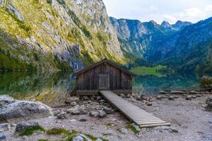 gamla trähus vid sjön obersee, koenigssee, konigsee, berchtesgaden nationalpark, bayern, tyskland. foto