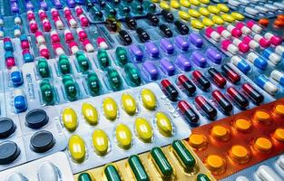 färgglada tabletter och kapslar piller i blisterförpackning arrangerad med vackert mönster. läkemedelsindustrin koncept. apotek apotek. defekt och fel i läkemedelsfabrikskonceptet. foto