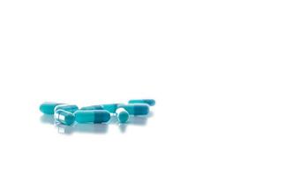 selektivt fokus på blå kapselpiller. grupp av mörkblå och ljusblå kapselpiller på vit bakgrund. sjukvård och medicin. läkemedelsindustri. apoteksprodukt. receptbelagda mediciner. foto