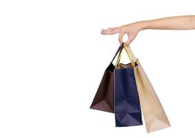 kvinna som bär papperspåsar isolerad på vit bakgrund. vuxen kvinna hand håller tre shoppingväska med blå och brun färg. kund och shoppingväska. svart fredag koncept. foto