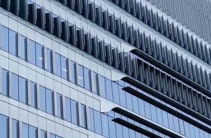 närbild fönster av skyskrapa glas kontorsbyggnad. exteriör kommersiell byggnad. modern arkitekturdesign. fasad av modern affärsglasbyggnad. fönster av glas byggnad textur bakgrund. foto