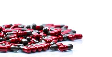 selektiv inriktning av röd-grå kapsel piller på vit bakgrund med utrymme. läkemedelsindustri. apoteksprodukt. läkemedelstillverkning. läkemedel globalt hälsovårdskoncept. foto
