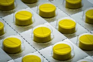 makro skott detalj av gula tabletter piller i blisterförpackning. full ram av tablettpiller foto