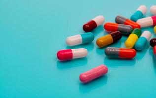 antibiotika kapsel piller på blå bakgrund. receptbelagda mediciner. färgglada kapselpiller. antibiotikaresistenskoncept. läkemedelsindustri. superbug problem. läkemedel och farmakologi. foto