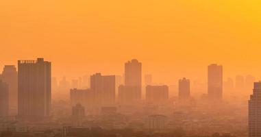 luftförorening. smog och fint damm från pm2,5 täckt stad på morgonen med orange soluppgångshimmel. stadsbild med förorenad luft. smutsig miljö. giftigt damm i staden. ohälsosam luft. ohälsosamt boende i städerna. foto