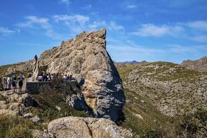 turister som utforskar steniga klippor mot blå himmel under sommarlovet foto