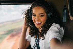 framgångsrik smart snygg ung latinsk kvinna i helikoptern. lyxigt livsstilskoncept foto