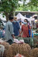chiang mai, thailand, 2021 - äldre thailändska män och kvinnor prutar om kostnaderna på lördagens loppmarknad i chiang mai. foto