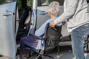 hjälp och stöd asiatiska senior eller äldre gammal dam kvinna patient sitter på rullstol förbereda komma till sin bil, hälsosamma starka medicinska koncept. foto