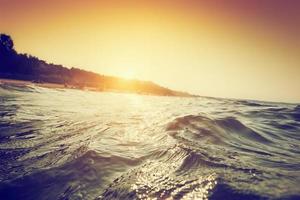 havets vågor och krusningar vid solnedgången. första persons perspektiv simning foto
