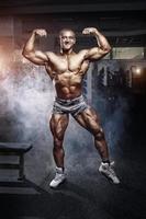 bodybuilder man poserar i gymmet foto
