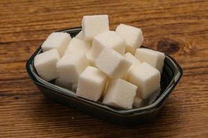 raffinerade vita sockerbitar i skålen foto