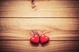 ett par röda små hjärtan på trä foto