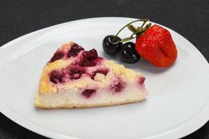 cheesecake med körsbär serveras jordgubbar foto