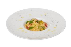 foto av läcker risotto maträtt med örter och tomat på vit bakgrund