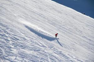 skidåkare går nerför backen på skidorten.