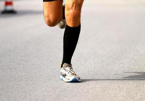 snabb löpare med sneakers under maraton på vägen