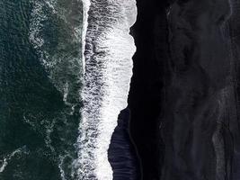 island svart sandstrand med enorma vågor vid reynisfjara vik. foto