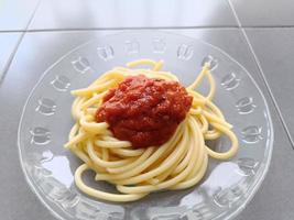 spaghetti nudlar tomatsås på tallrik, närbild foto