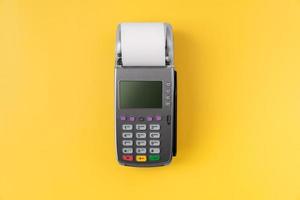 kortläsare maskin med faktura räkning på gul bakgrund. online betalning koncept. foto
