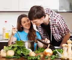 man och ung kvinna som lagar mat tillsammans