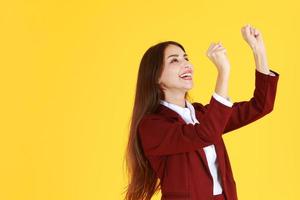 framgångsrik affärskvinna leende och räckte upp handen för framgång i jobb isolerad på gul bakgrund foto