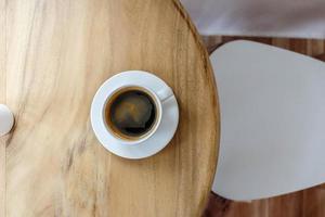 varmt svart kaffe på ett träbord i ett café foto