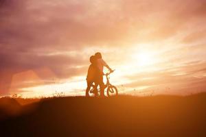 två små pojkar cykel siluett foto