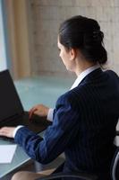 säker affärskvinna att skriva på bärbar dator bakifrån