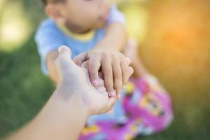 glad mulatt pojke barn ler och njuter av adoptivlivet. porträtt av ung pojke i naturen, parken eller utomhus. begreppet lycklig familj eller framgångsrik adoption eller föräldraskap. foto