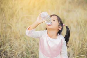 liten flicka dricksvatten. foto