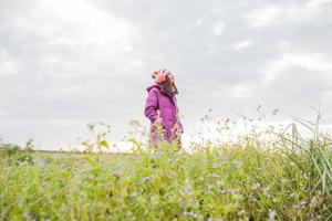 ung kvinna lekte i ett fält av blommor i vinterluften. foto