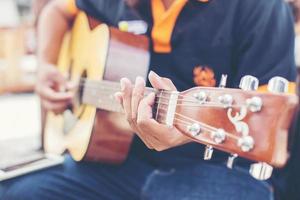 närbild av manhand som spelar gitarr foto