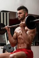 muskulösa män som gör träning med tung vikt för biceps foto