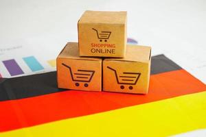 online shopping, kundvagnslåda på tysk flagg, import export, finanshandel. foto