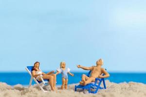 miniatyr människor lycklig familj avkopplande på stranden foto