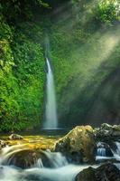 morgonvy vid vackert vattenfall med strålande sol foto