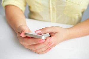 kvinnlig hand som håller en mobiltelefon foto