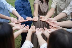 grupp asiatiska människor räcker upp sina högra händer och hanterar varsamt för att få och dela bra känsla för att tillsammans träna teambuilding. foto