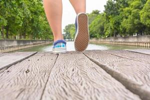 canvas sneakers på fötter på träbron foto