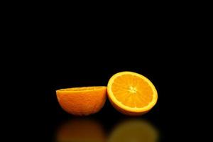en fräsch och frisk apelsin på svart bakgrund. foto