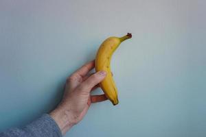 hand som håller en banan, frisk frukt foto