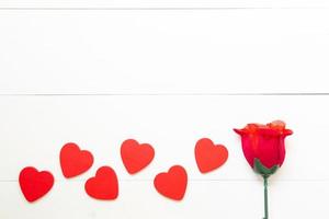 presentgåva med röd ros blomma och hjärta form trä på träbord, 14 februari av kärleksdagen med romantisk kopia utrymme, alla hjärtans semester koncept, ovanifrån. foto