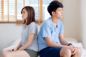 förhållandet mellan ungt asiatiskt par som har problem på sängen i sovrummet hemma, familj som har konfliktargument med olyckliga, man och kvinna med problem, misslyckande och stress tillsammans. foto