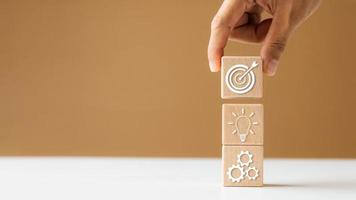 hand woods block kub med ikon företag strategiutveckling, koncept framgång och affärsmål. foto