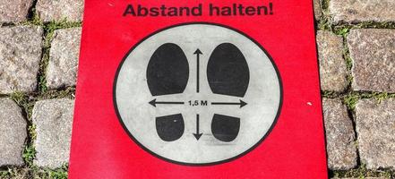 håll avståndssymbol på tyska 2 meter social distanseringsskylt för covid 19. foto