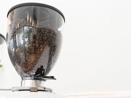 kaffebönor i maskin. närbild av kaffebönor i en kvarn foto
