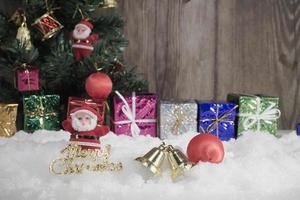 Jultomten docka och dekorationer placerade på snön och julgranen bakgrund och wood.selective fokus foto